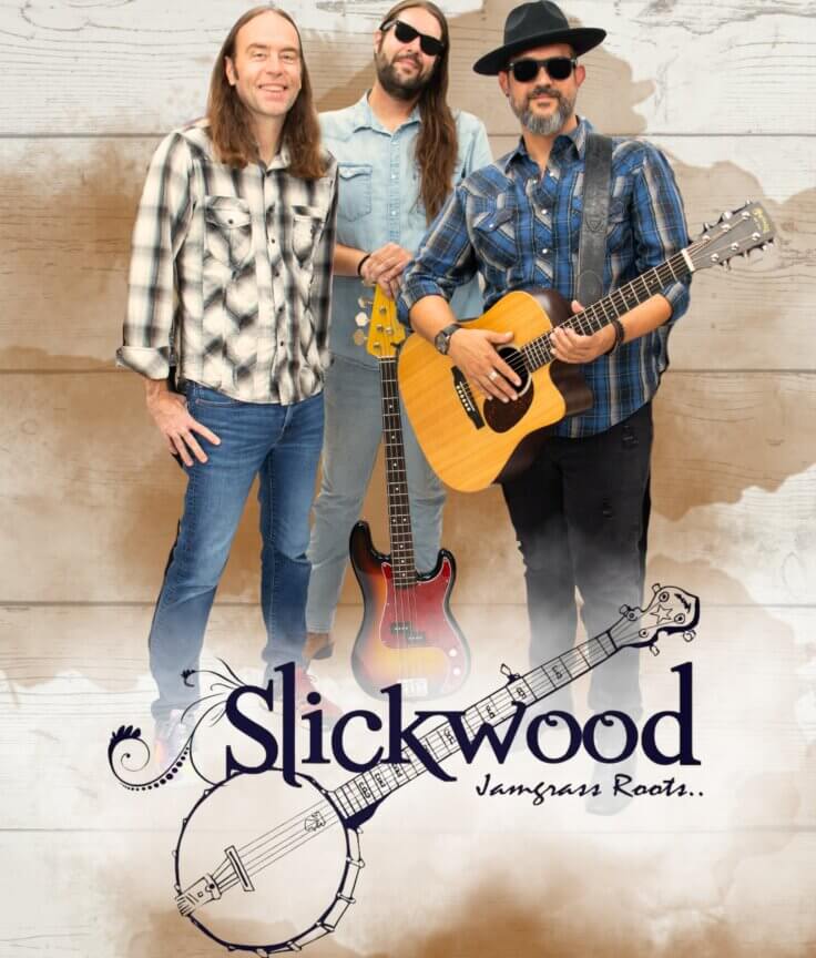 Three men in casual clothes stand together, two holding guitars. The background is wood with a faded watercolor effect. At the bottom, Slickwood and Jamgrass Roots... are written with a banjo illustration.
